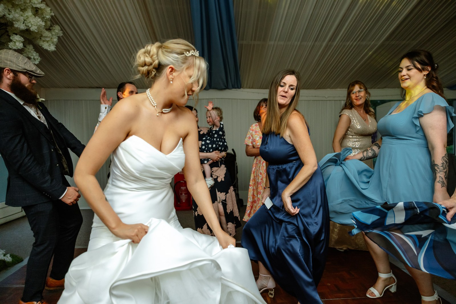 The bride dancing with her bridesmaids, skirts swishing