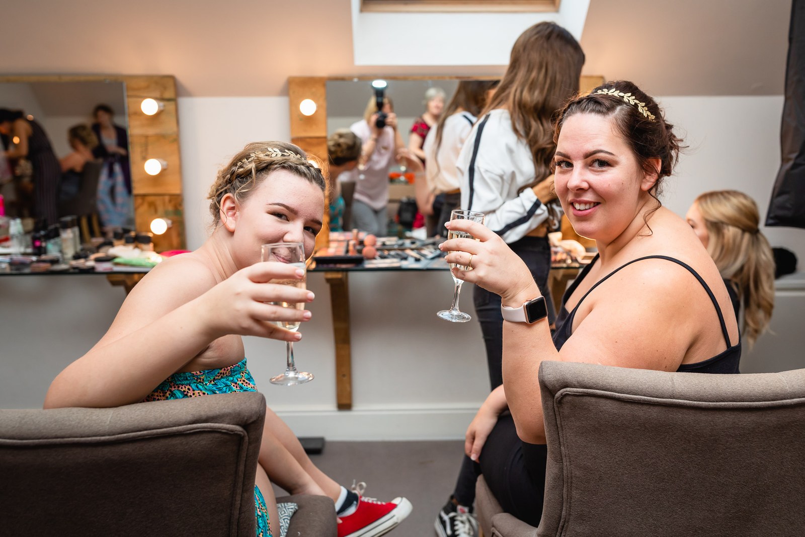 Two bridesmaids raising a champagne toast during the morning preparations