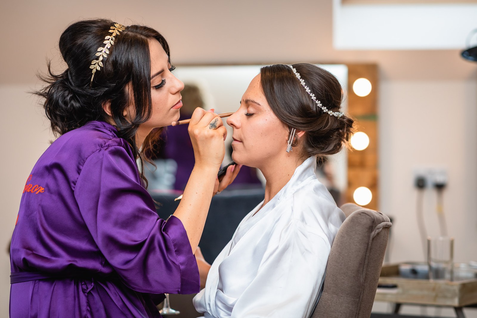 A make-up artist applying the finishing touches to the bride