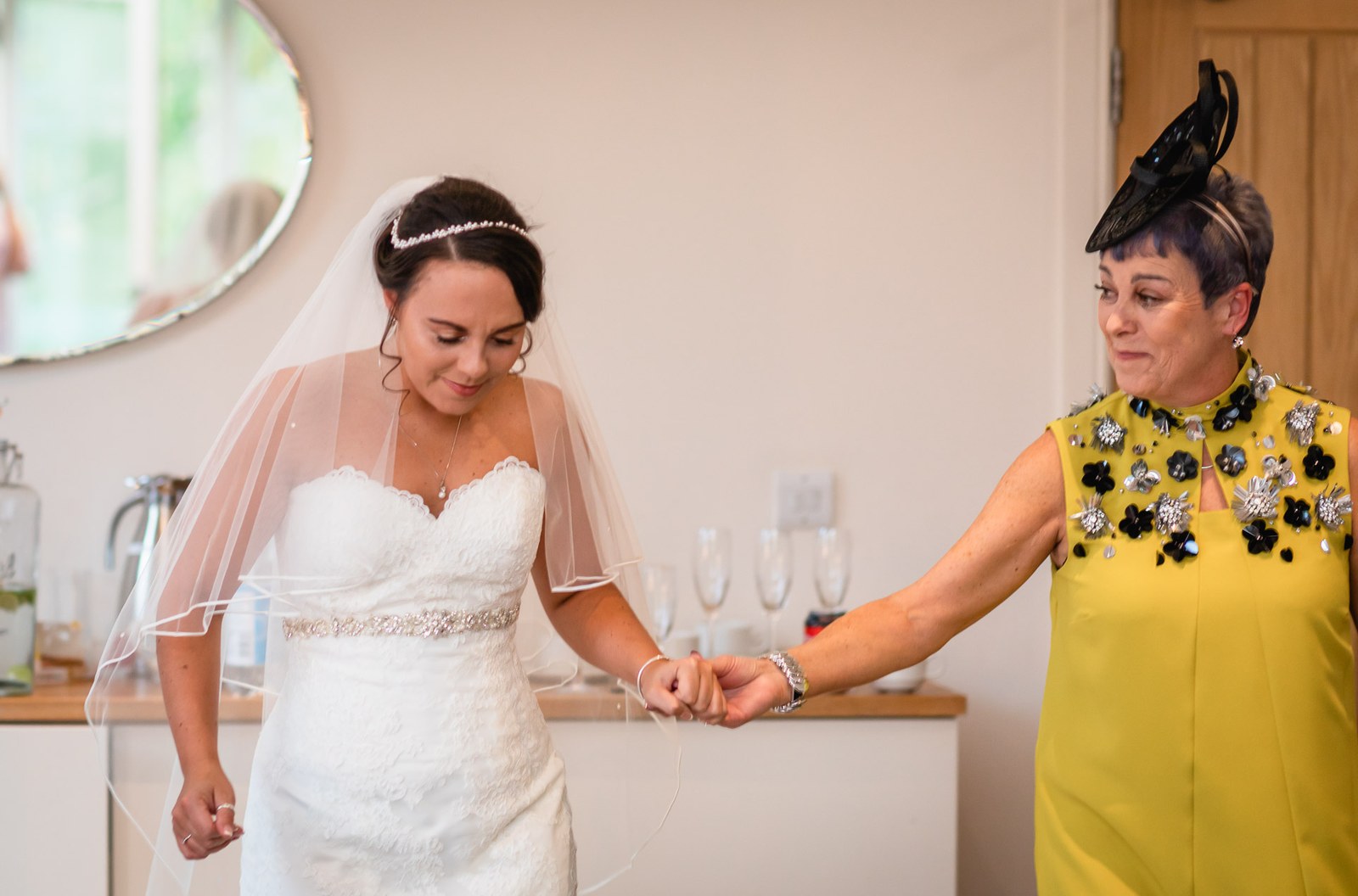 The bride holding hands with her mother before the ceremony