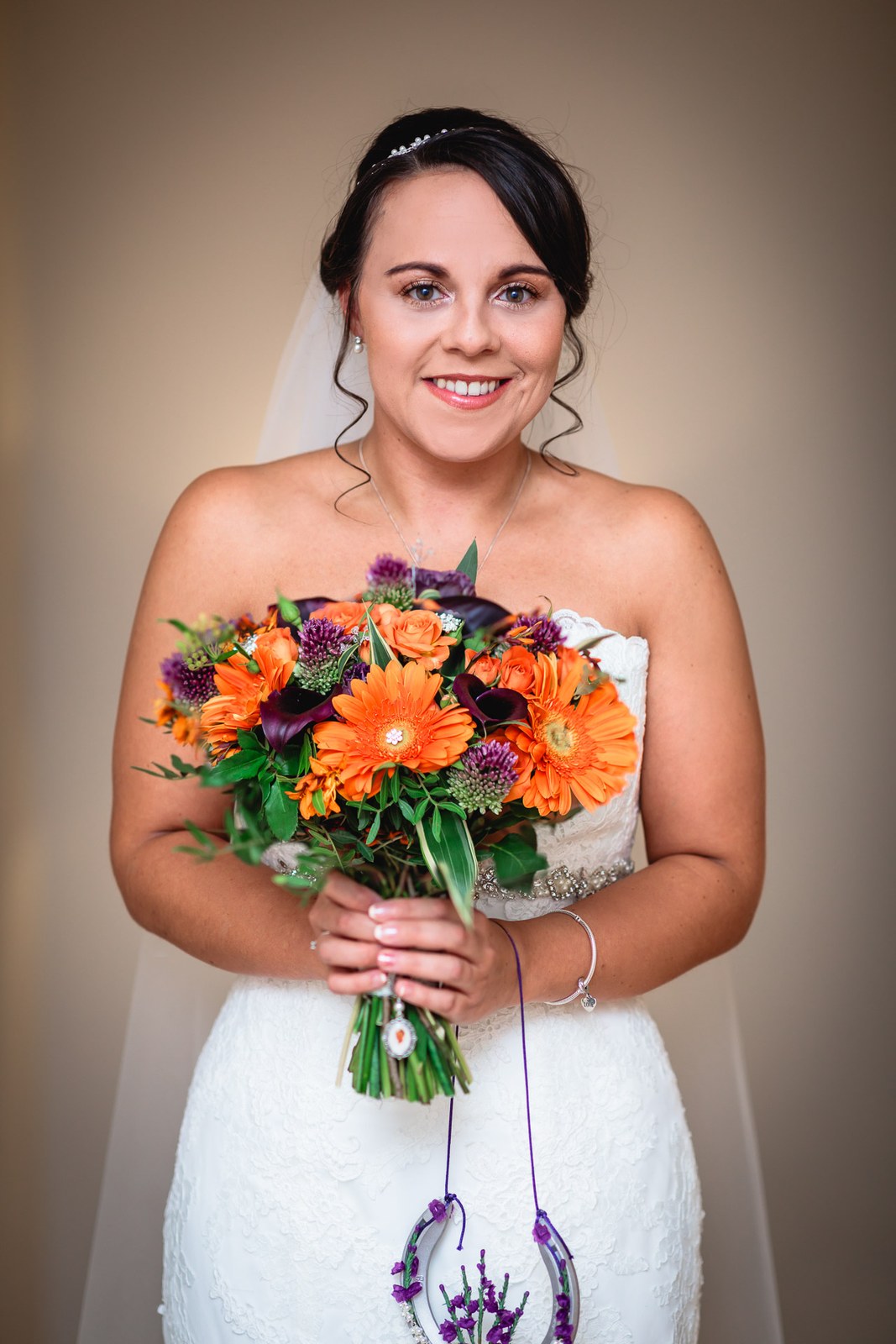 Portrait of the bride holding her autumn bouquet with a lucky horseshoe