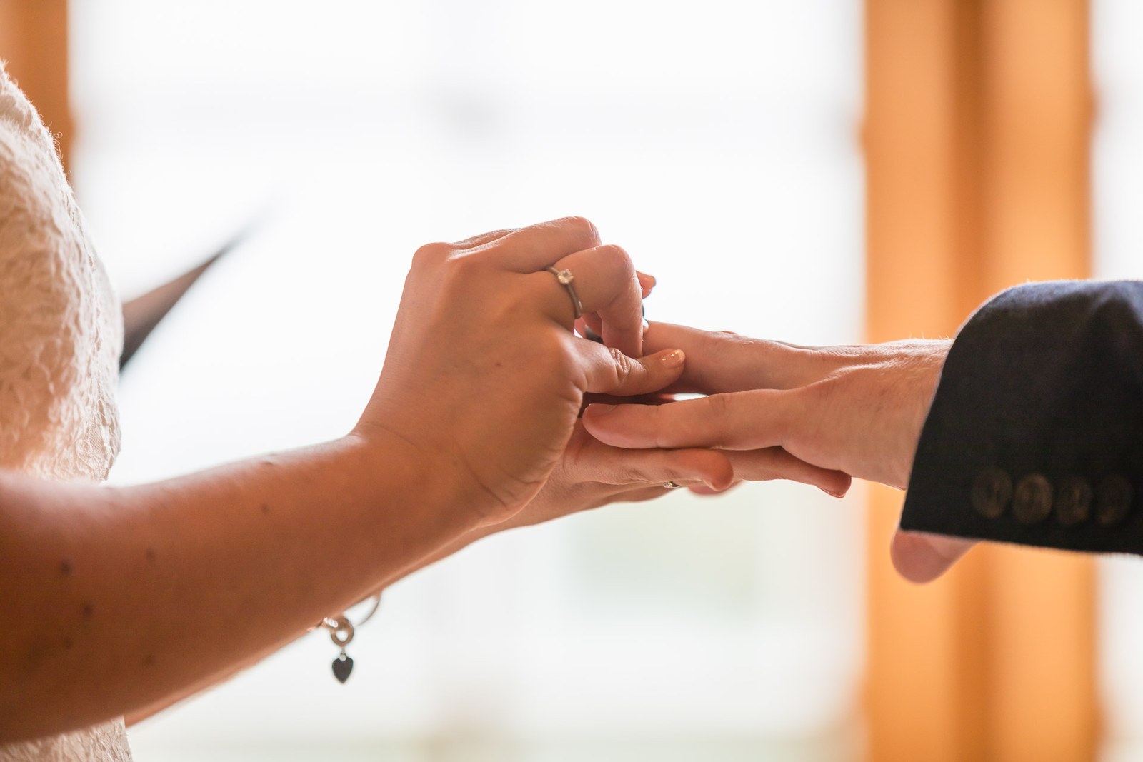 Close-up of the ring being slipped onto the finger during the vows