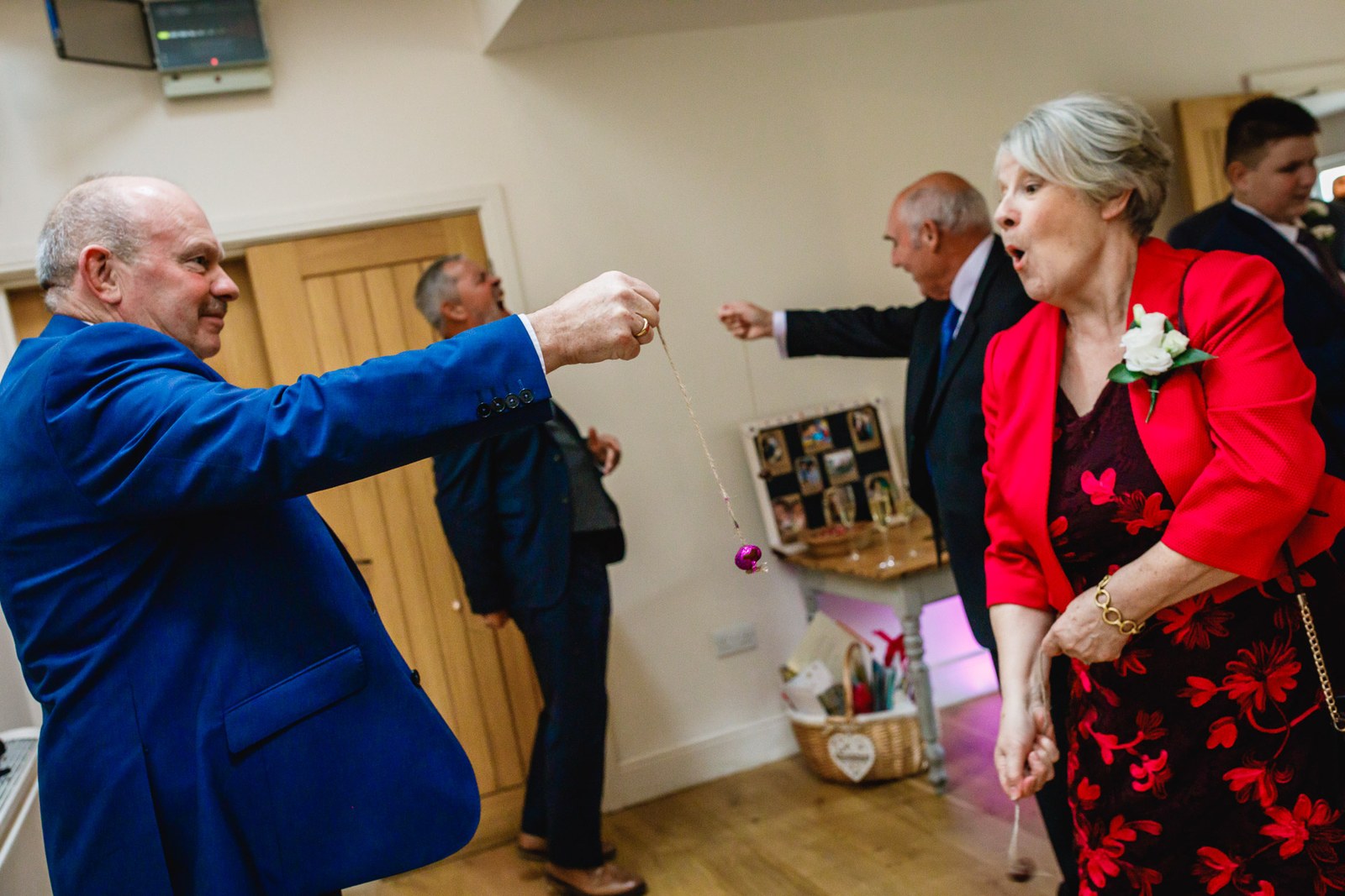 A guest dangling a pendant on a string during a lighthearted party game