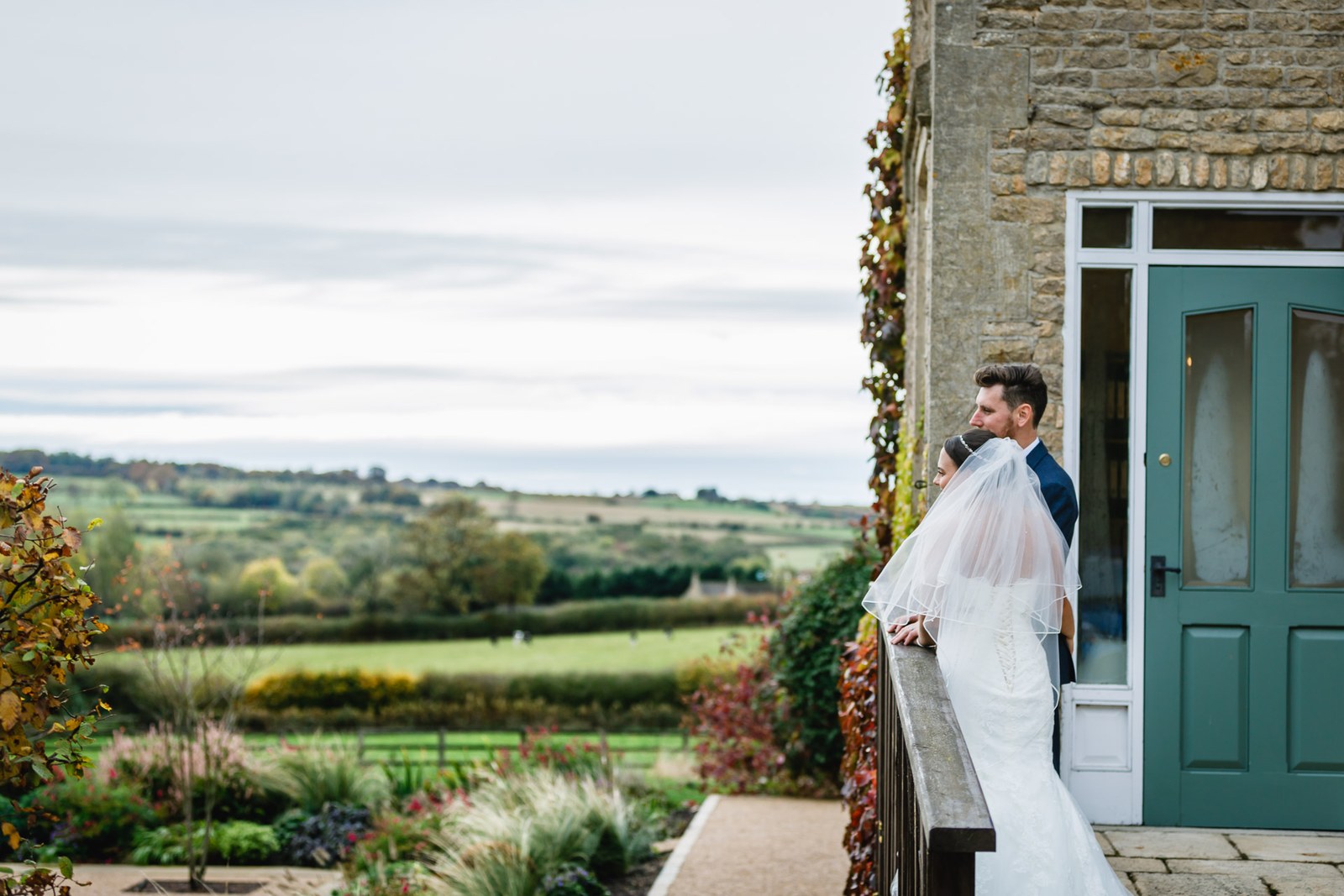 The couple on the terrace at Hyde House looking out over the Cotswold countryside