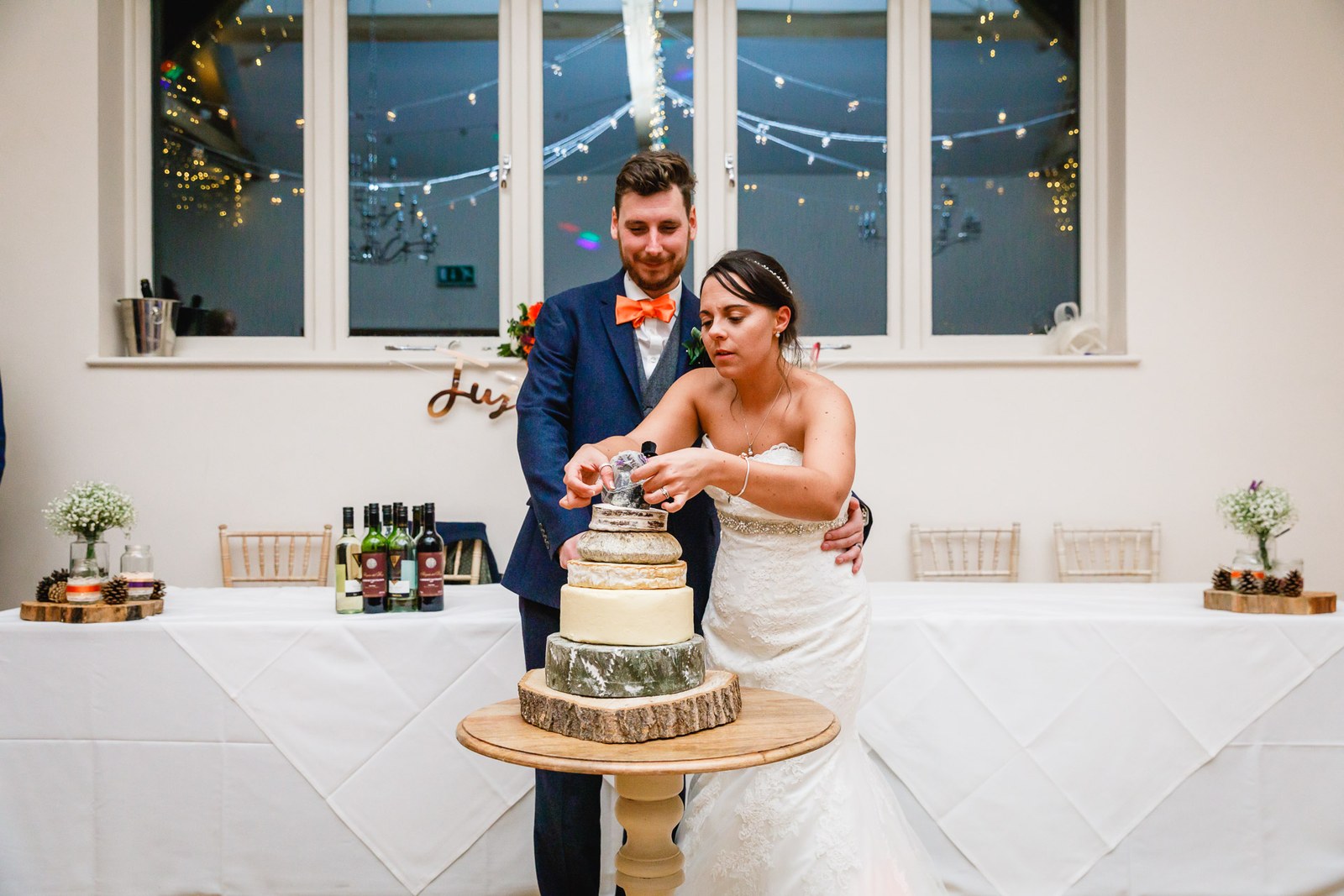 Bride and groom cutting the stacked cheese cake at the reception