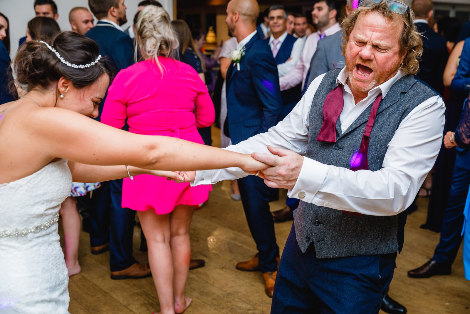 The bride dancing hand in hand with a guest on the dance floor