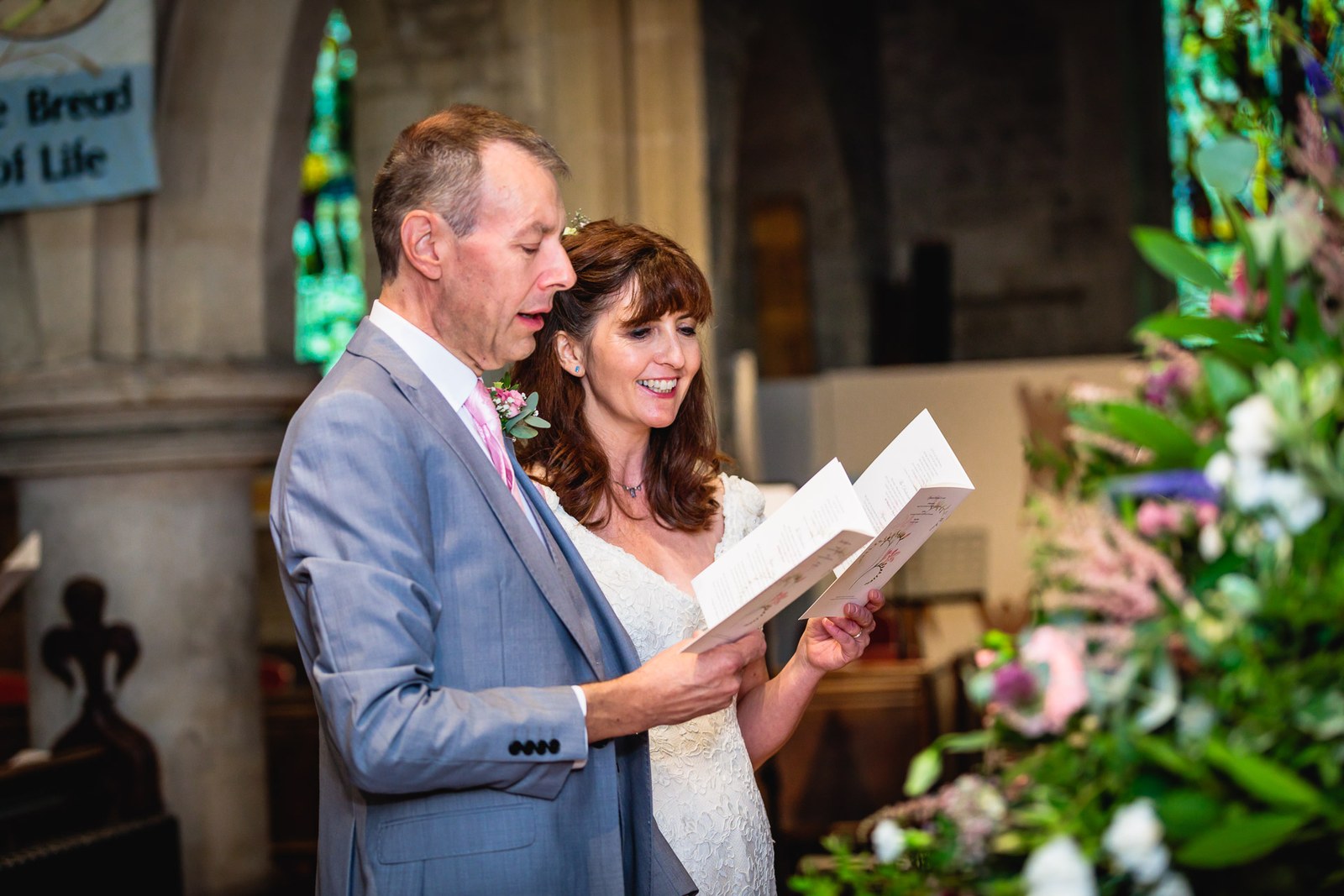 Bride reading aloud from a sheet beside the groom during the ceremony