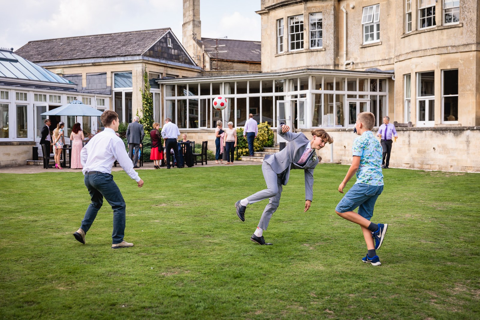 Guests playing football on the lawn with the hotel and conservatory behind
