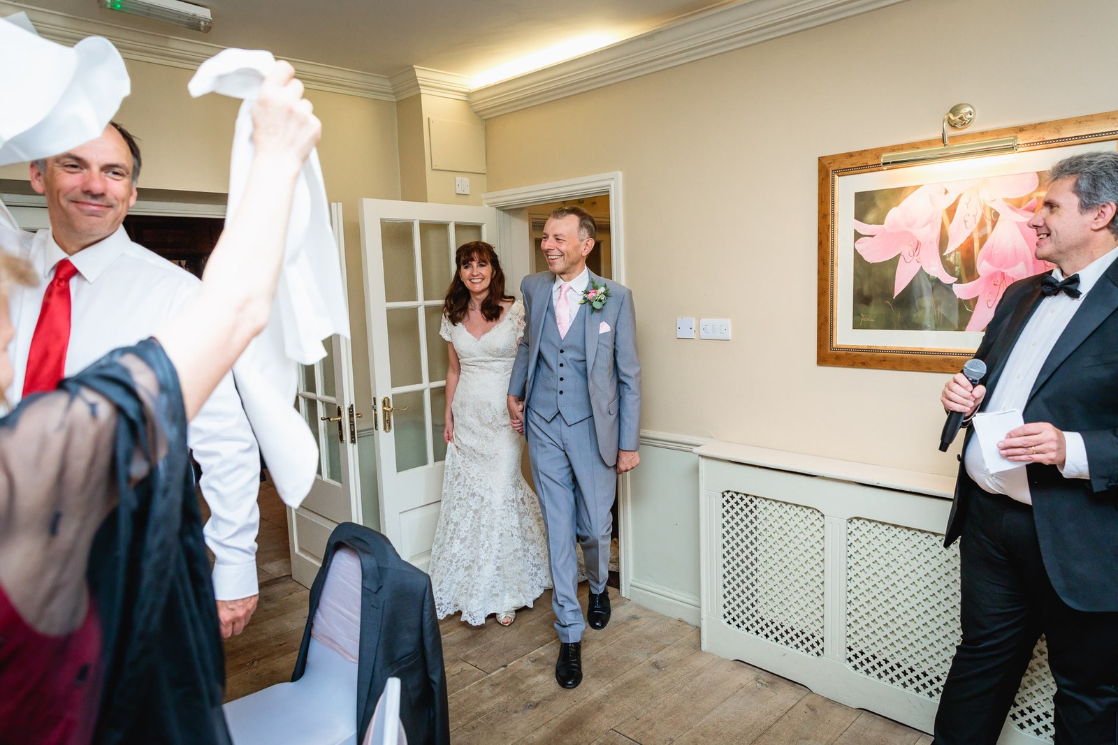 Guests waving napkins as the couple enter the reception room