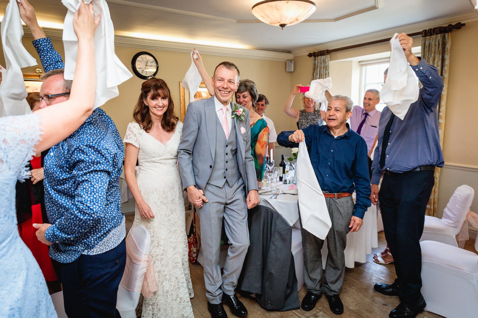 Guests circling the couple and waving napkins in the reception room