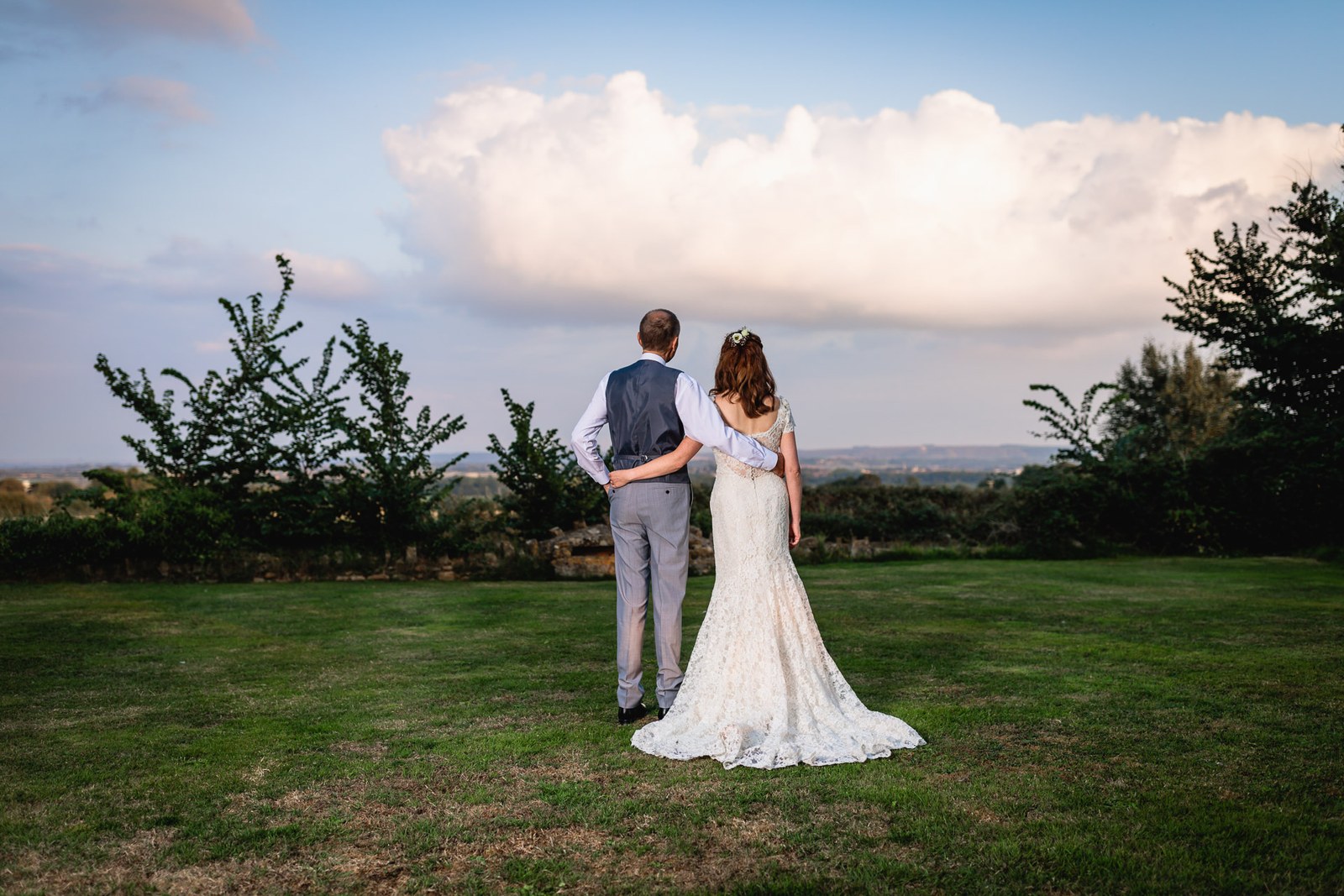 Bride and groom from behind looking out over the view at dusk
