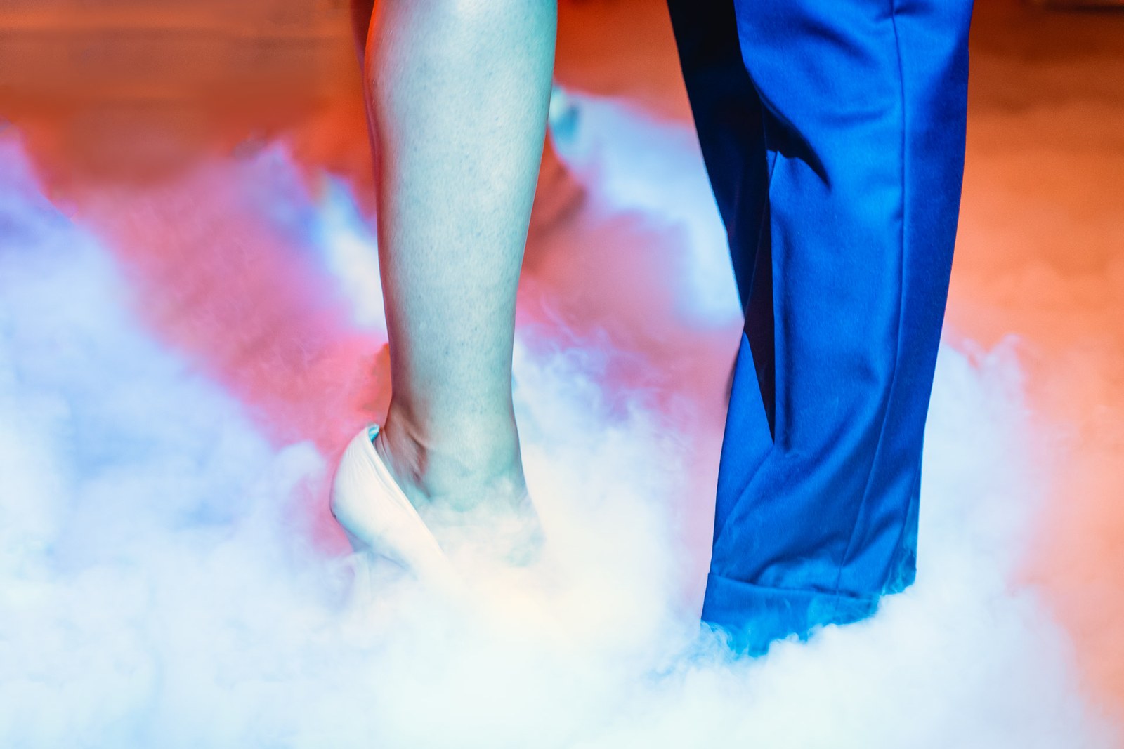 Close-up of the couple's feet dancing in low-lying dry-ice fog