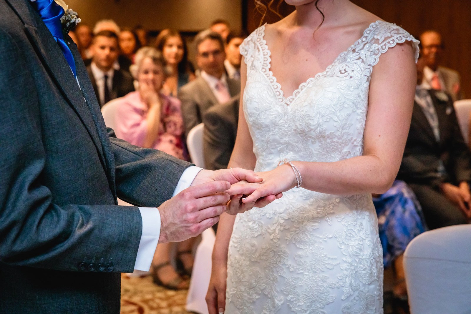 Close-up of the groom placing the ring on the bride's finger during the vows