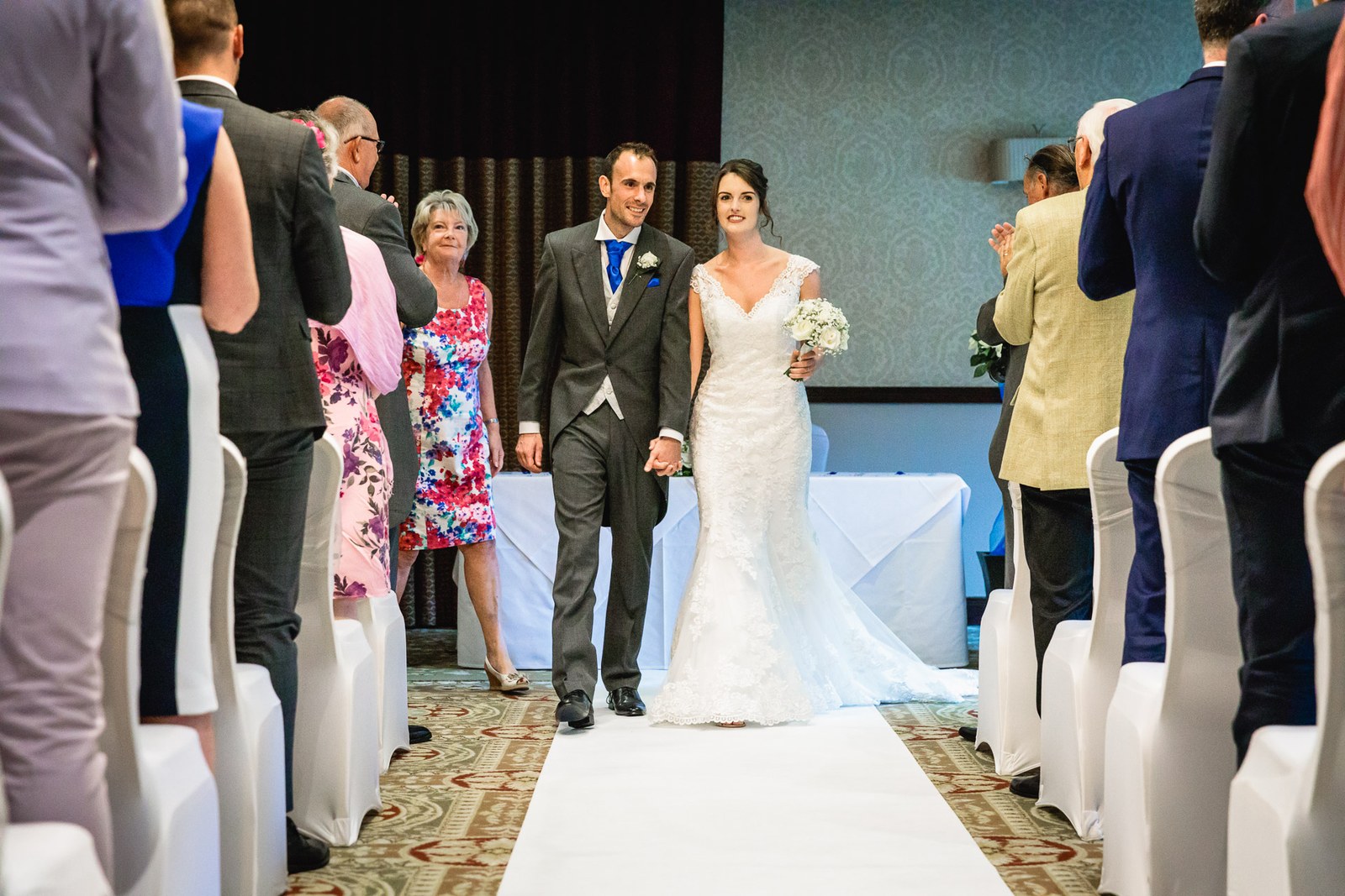 The newlyweds walking back down the aisle between their guests