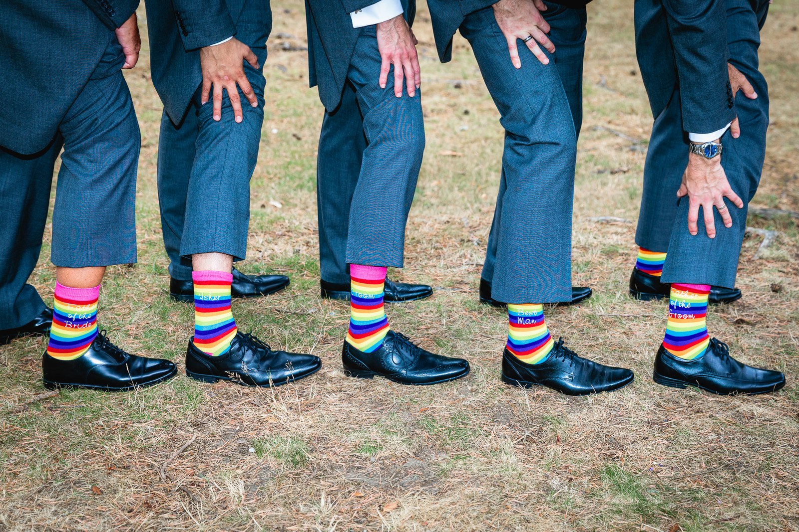 Close-up of the groomsmen's legs and shoes with their bright rainbow socks