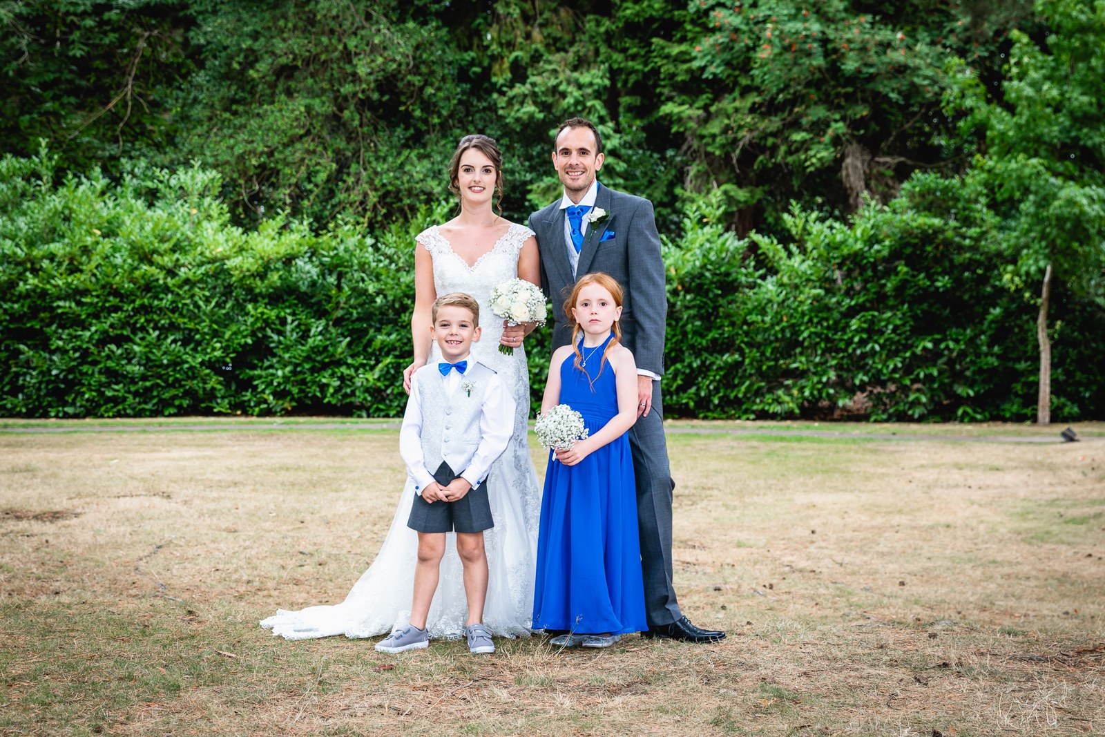 Bride and groom with a page boy and flower girl in the grounds