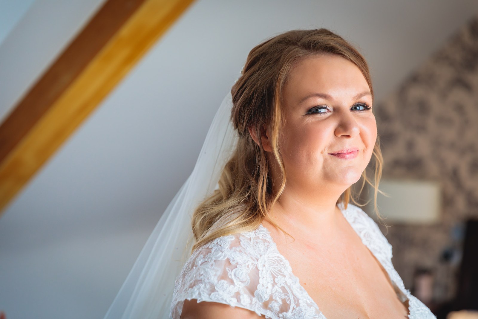 Portrait of the bride in her lace gown and veil looking over her shoulder