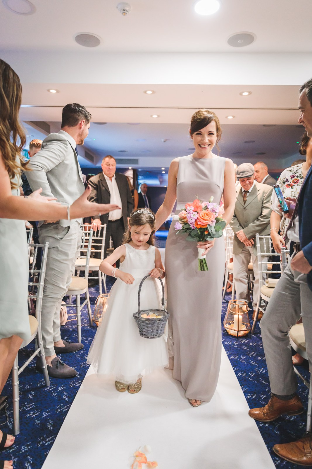 A bridesmaid and flower girl with a petal basket walking down the aisle