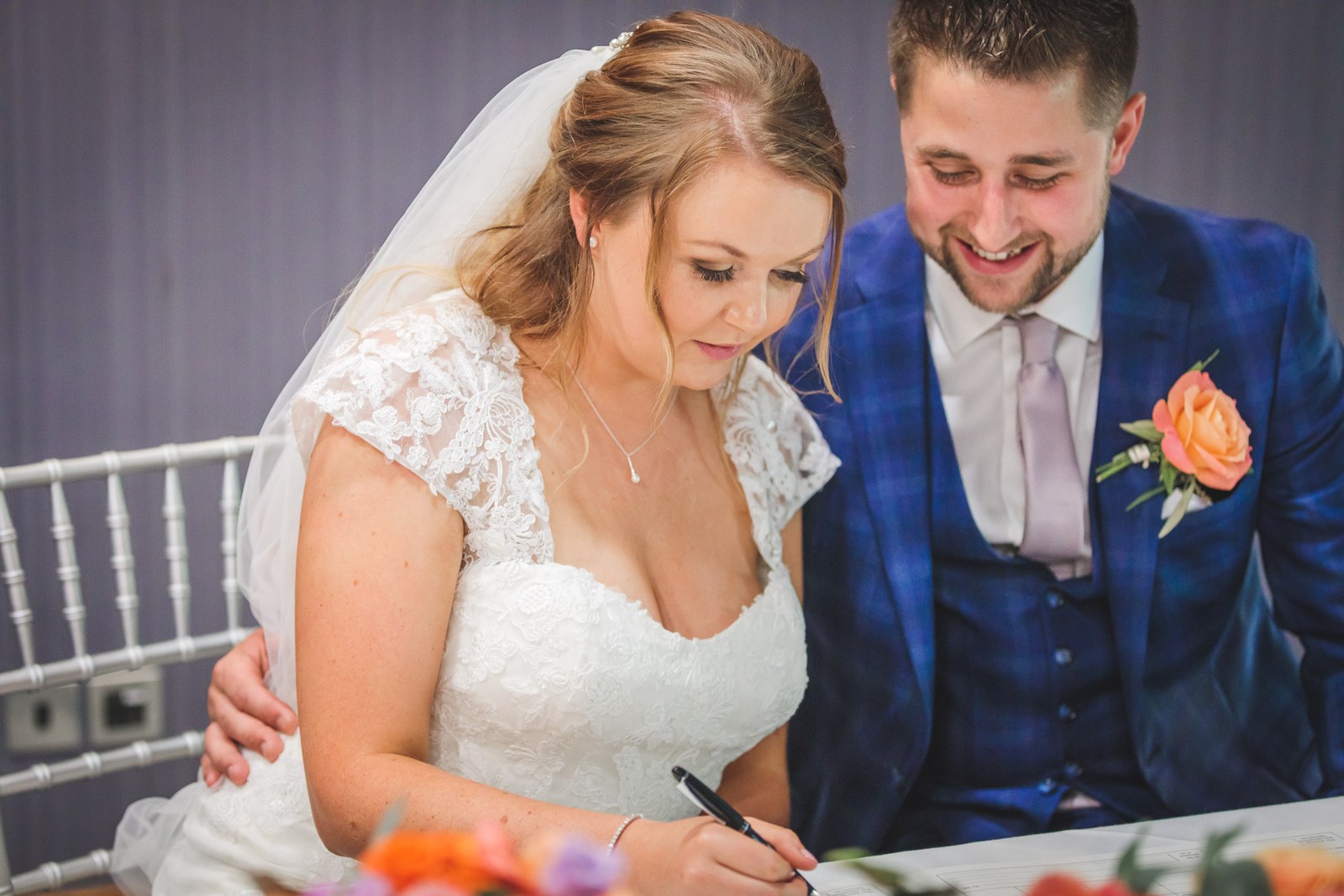 Bride and groom signing the register at the table