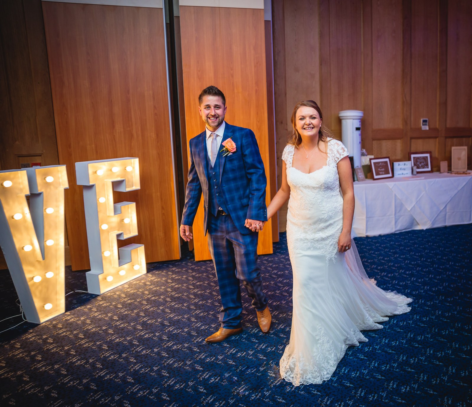 Bride and groom entering the Mandolay Hotel reception beside glowing LOVE letters
