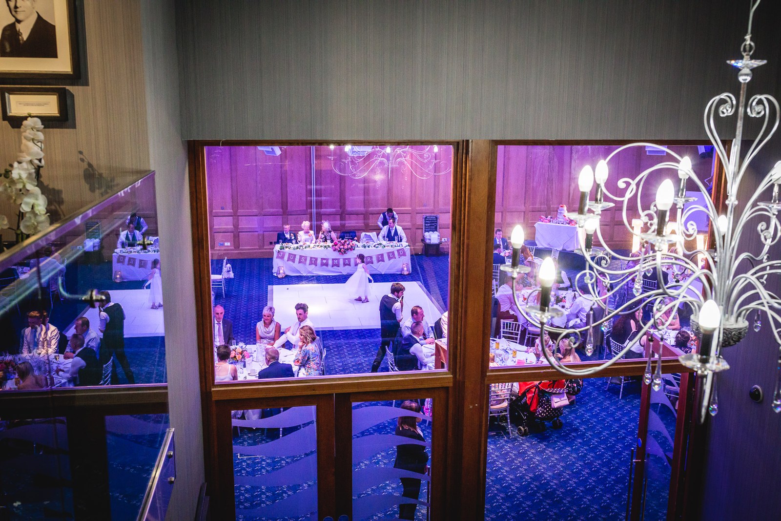 View through a window of the candlelit reception room beyond a chandelier