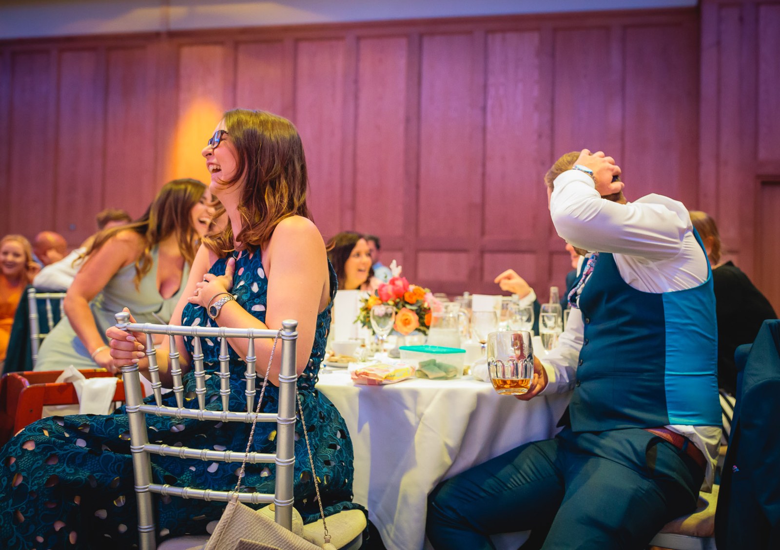 Guests laughing around a table during the speeches