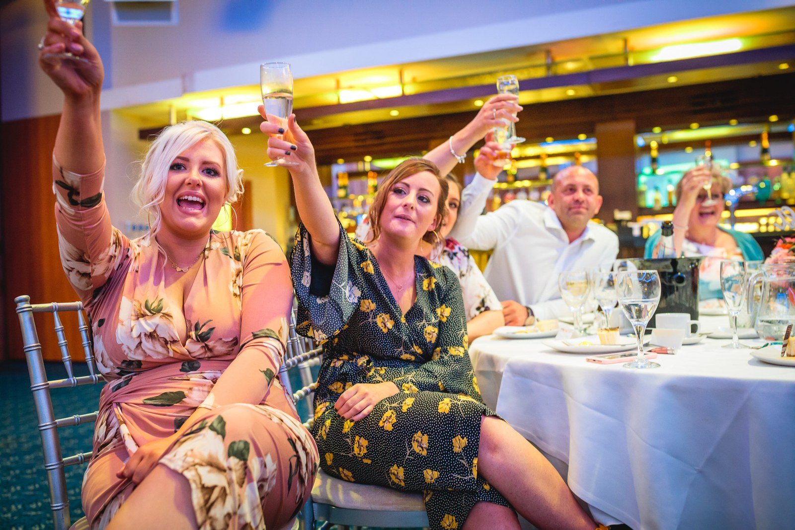 Female guests raising their glasses in a laughing toast