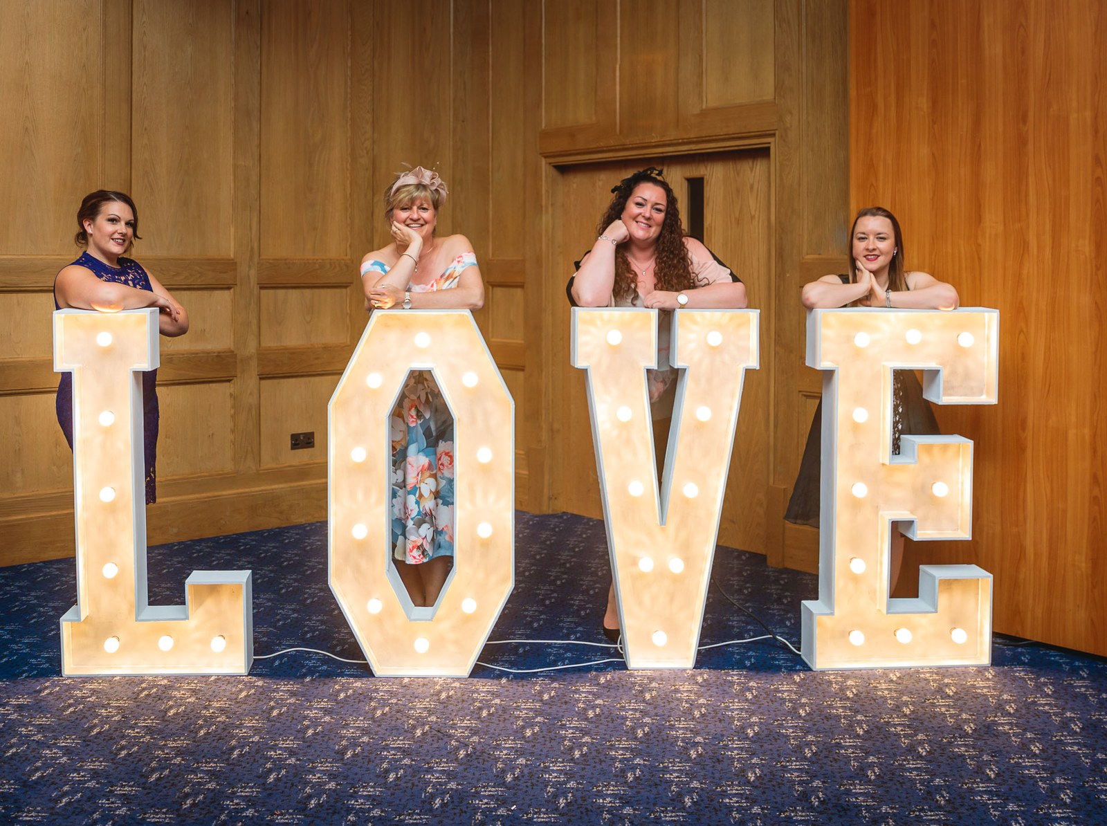 Guests peering over the illuminated LOVE letters in the reception