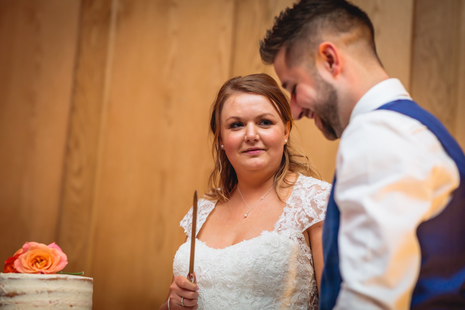 Bride holding the knife as the couple prepare to cut the cake