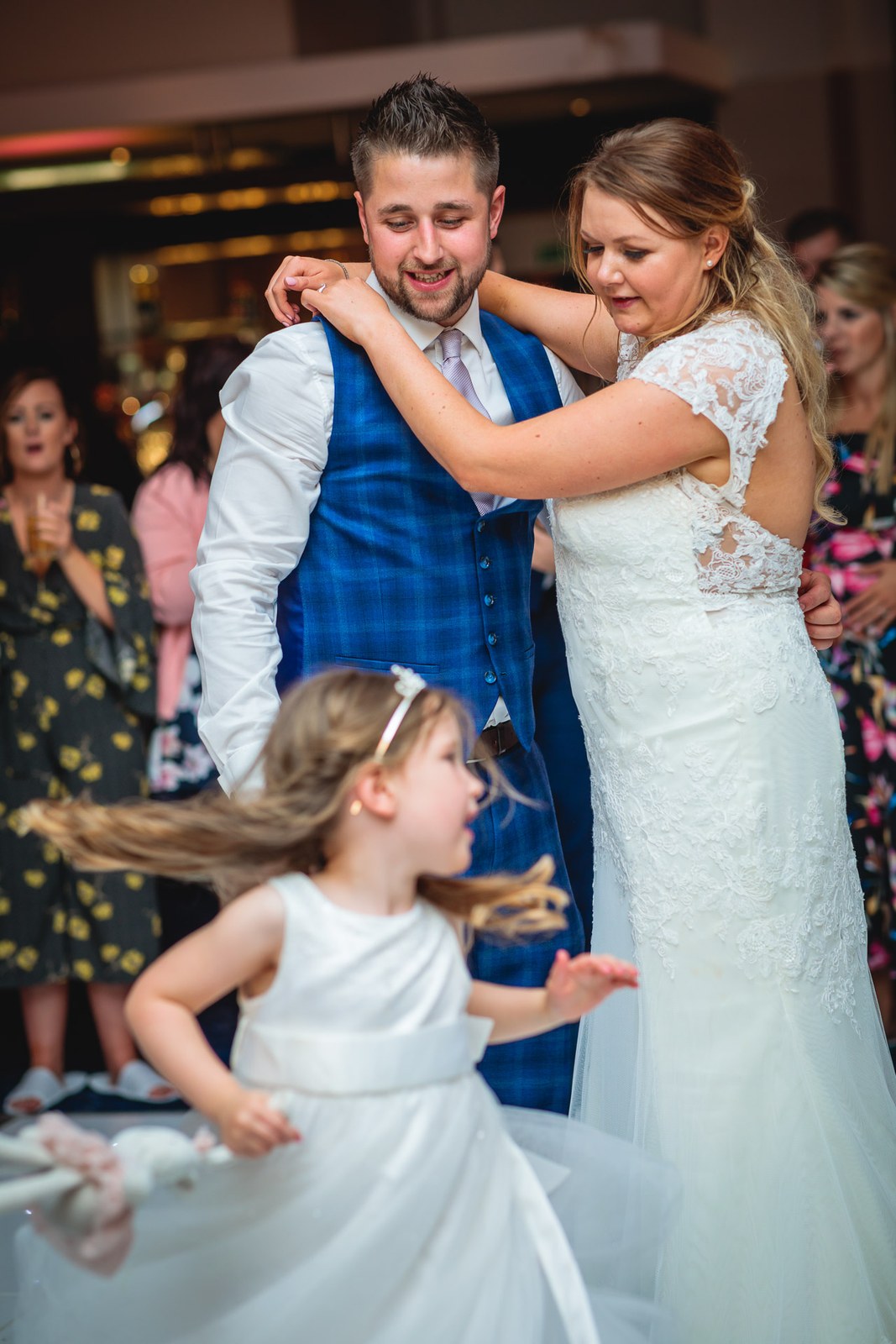 The couple's first dance as a flower girl twirls beside them