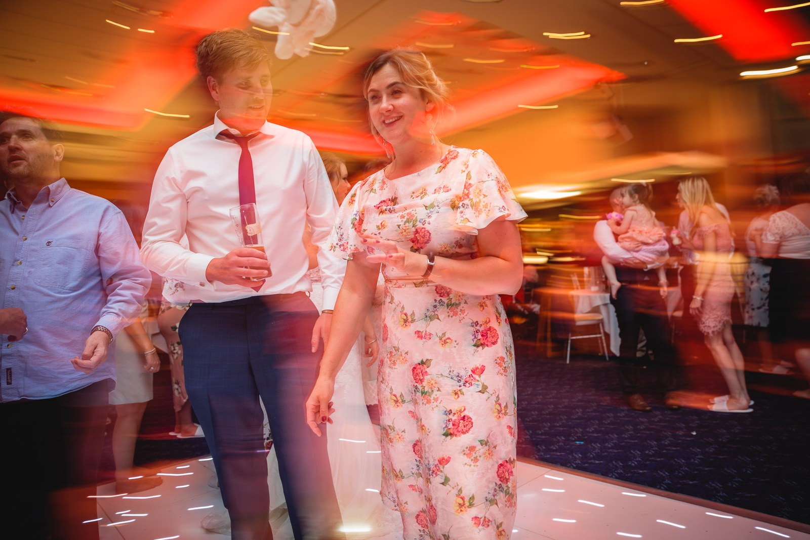 Blurred motion of guests dancing and mingling in the reception