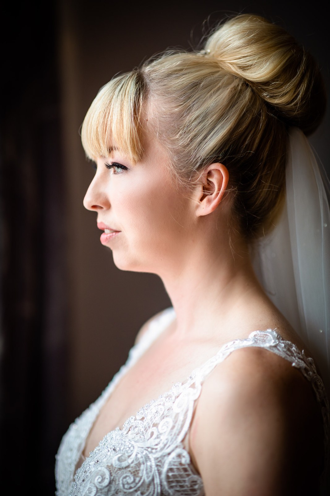Side-profile portrait of the bride with her hair up and veil