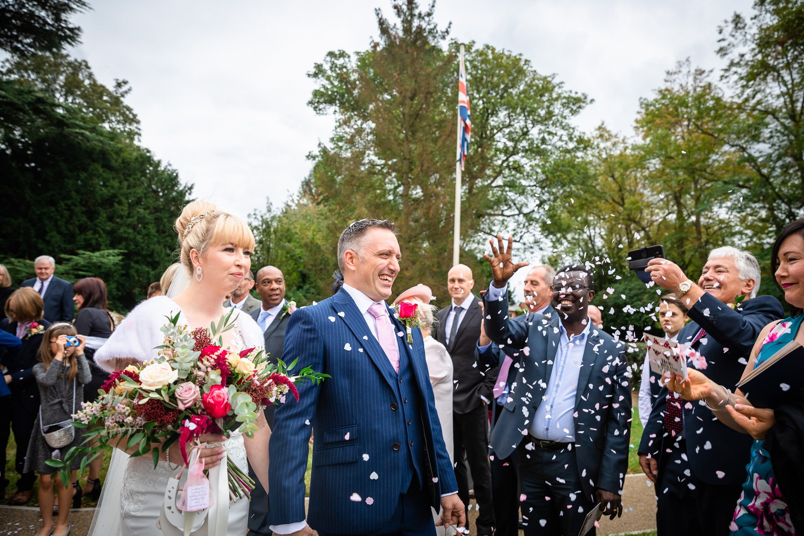 Bride and groom leaving the church into a shower of confetti