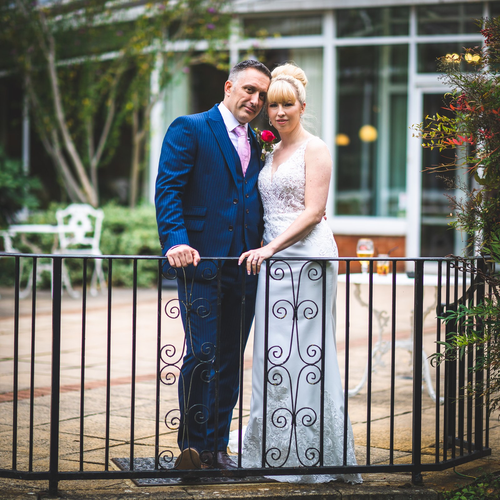 The couple leaning together on the iron terrace railing at Moore Place Hotel