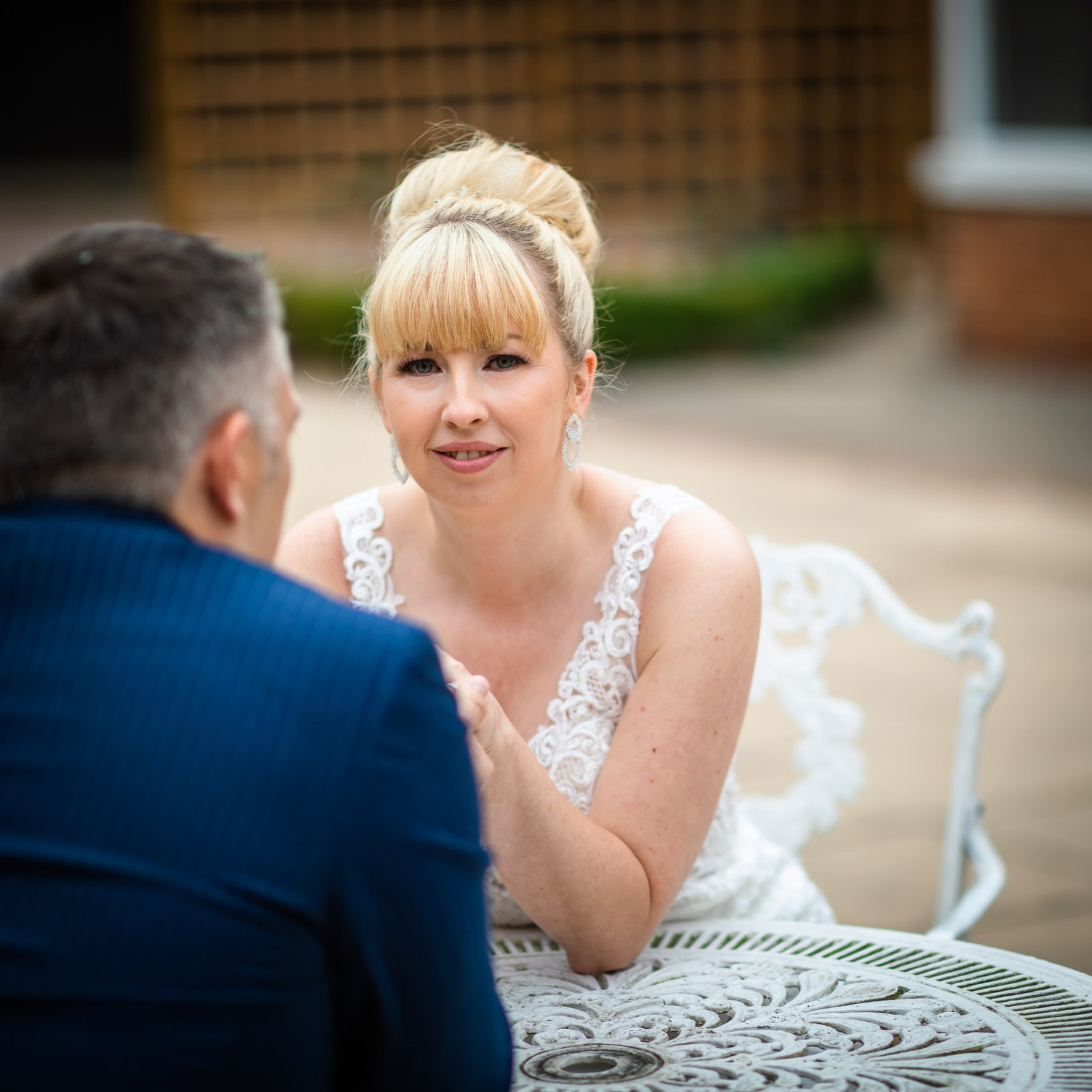 Bride and groom at the garden table, the bride looking to camera