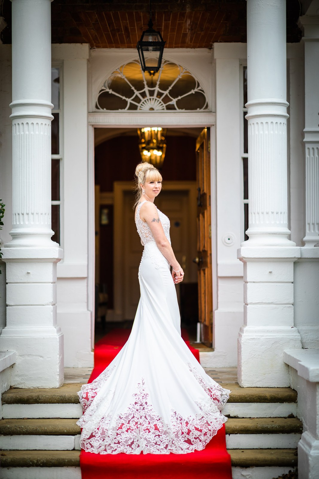 Bride showing the sheer lace train of her gown on the entrance red carpet