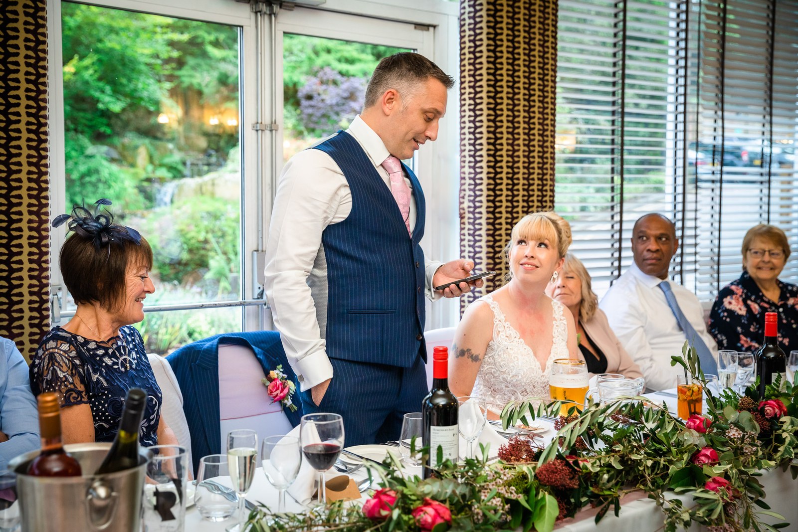 The groom giving his speech at the top table as guests listen