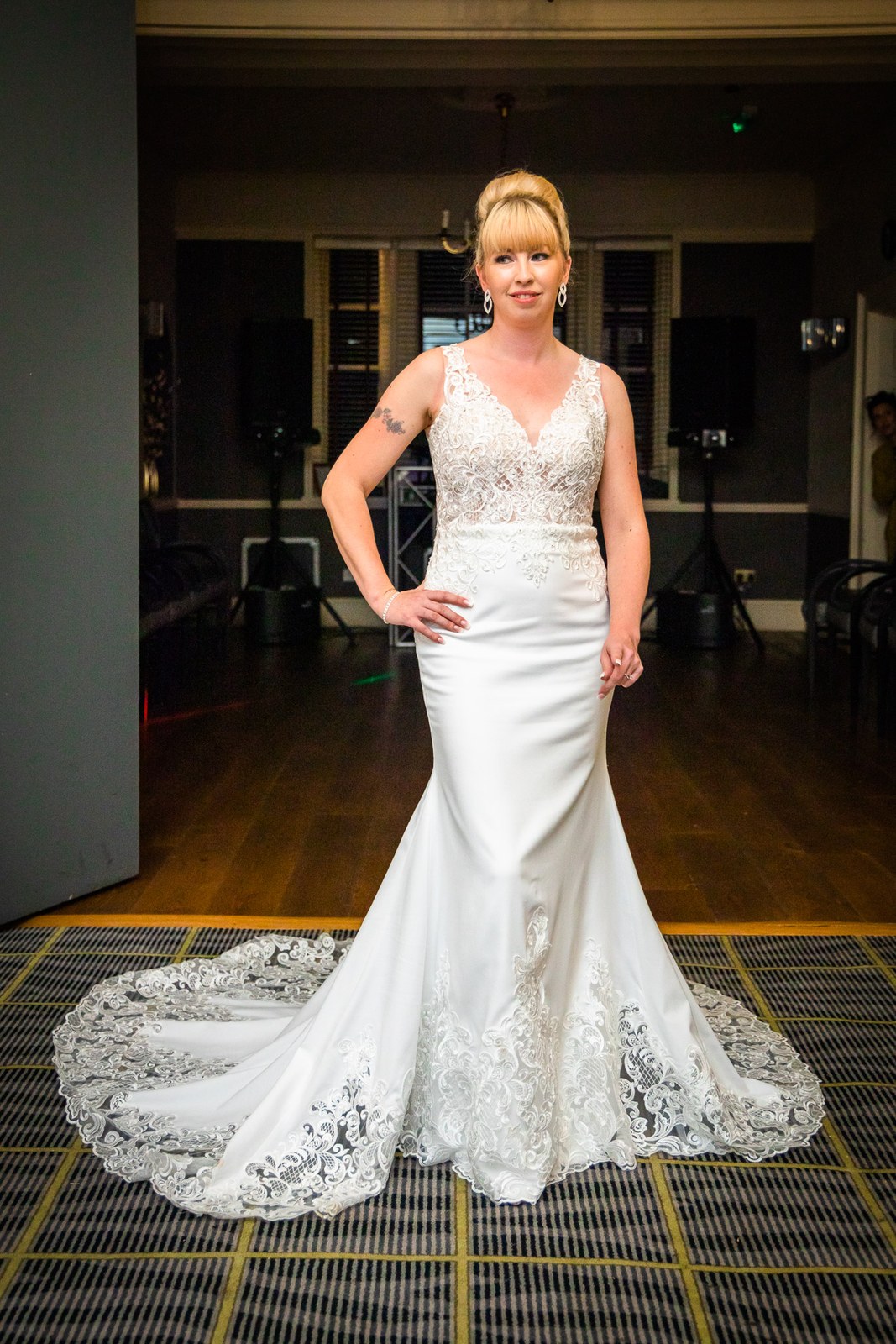 Full-length portrait of the bride showing her train in the reception room