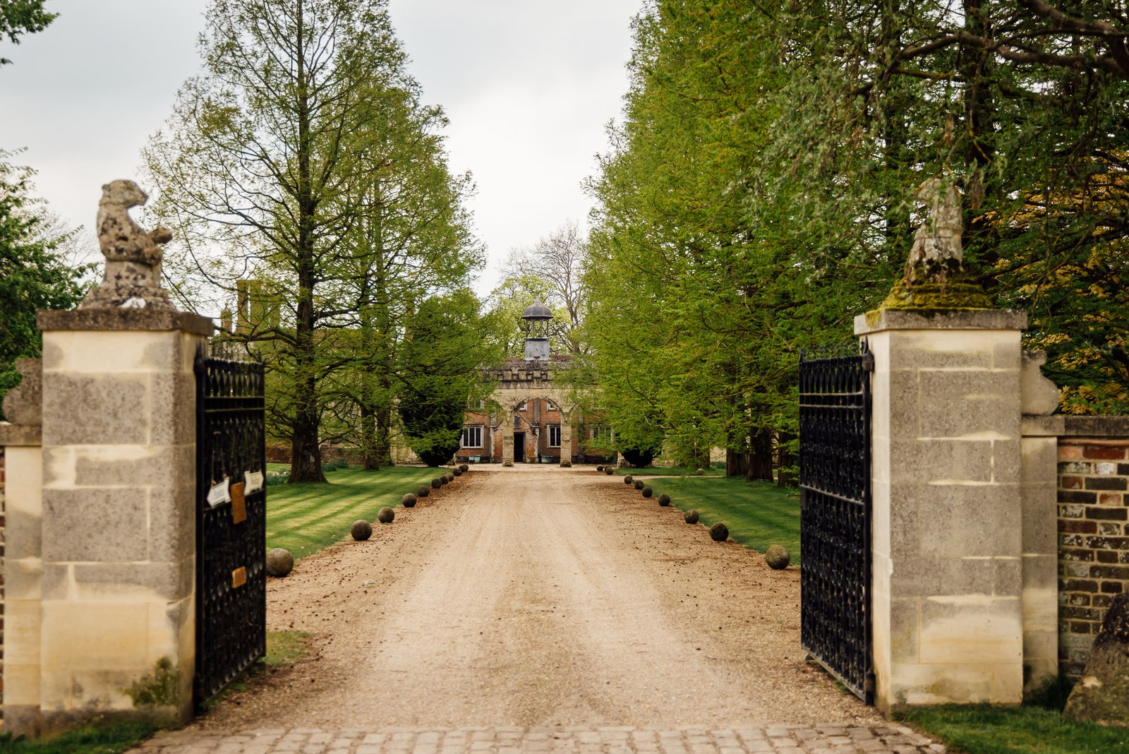 View through the stone gate piers down the tree-lined drive to Nether Winchendon House