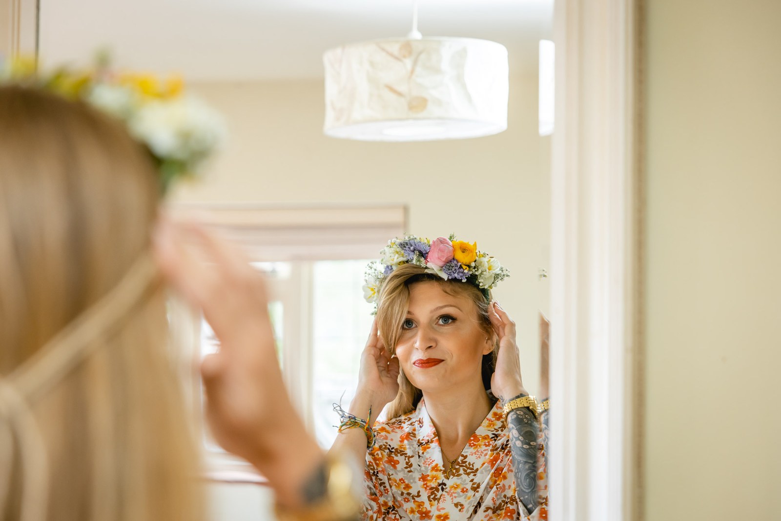 Bride adjusting her fresh flower crown in a mirror