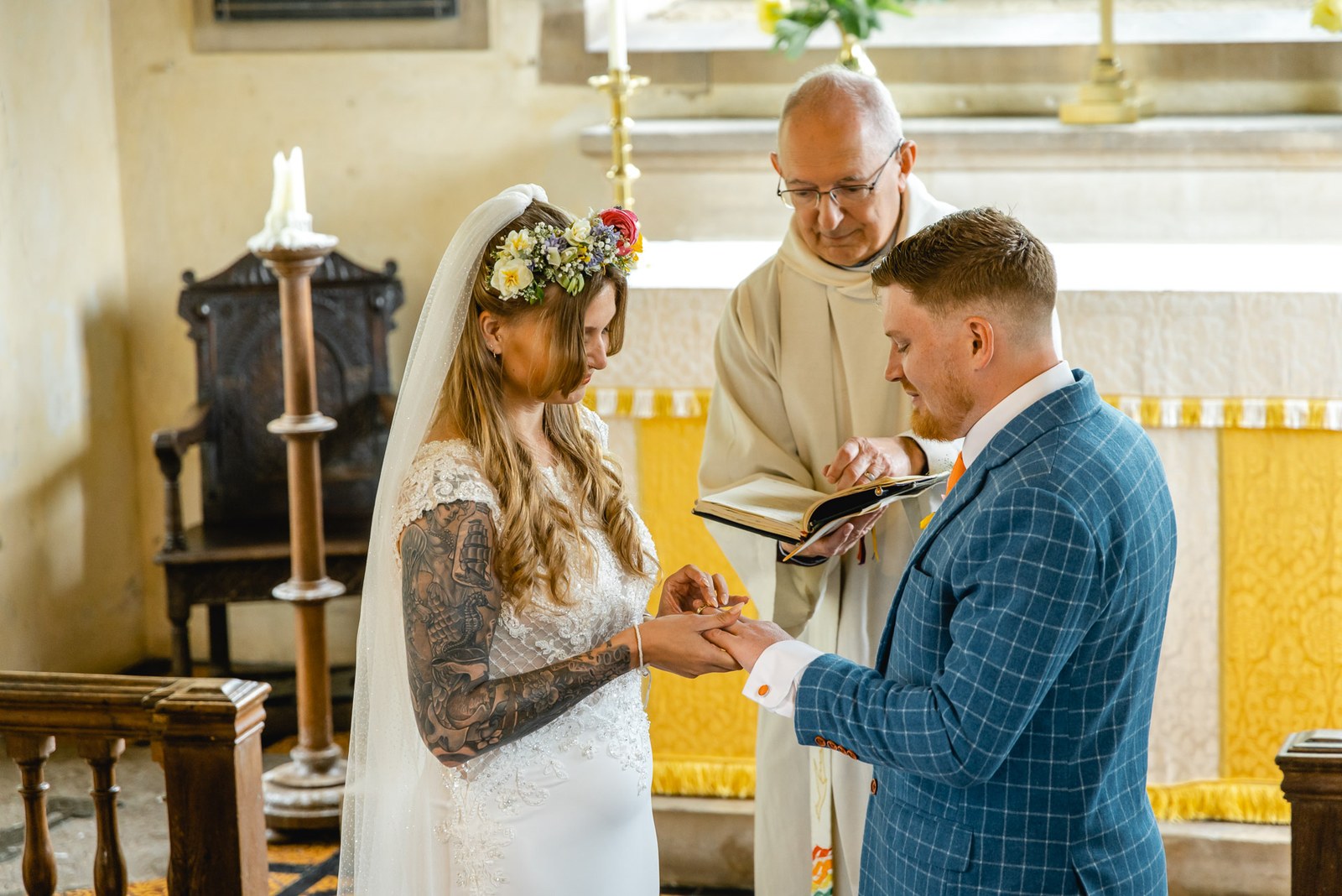 The groom placing the wedding ring on the bride's finger