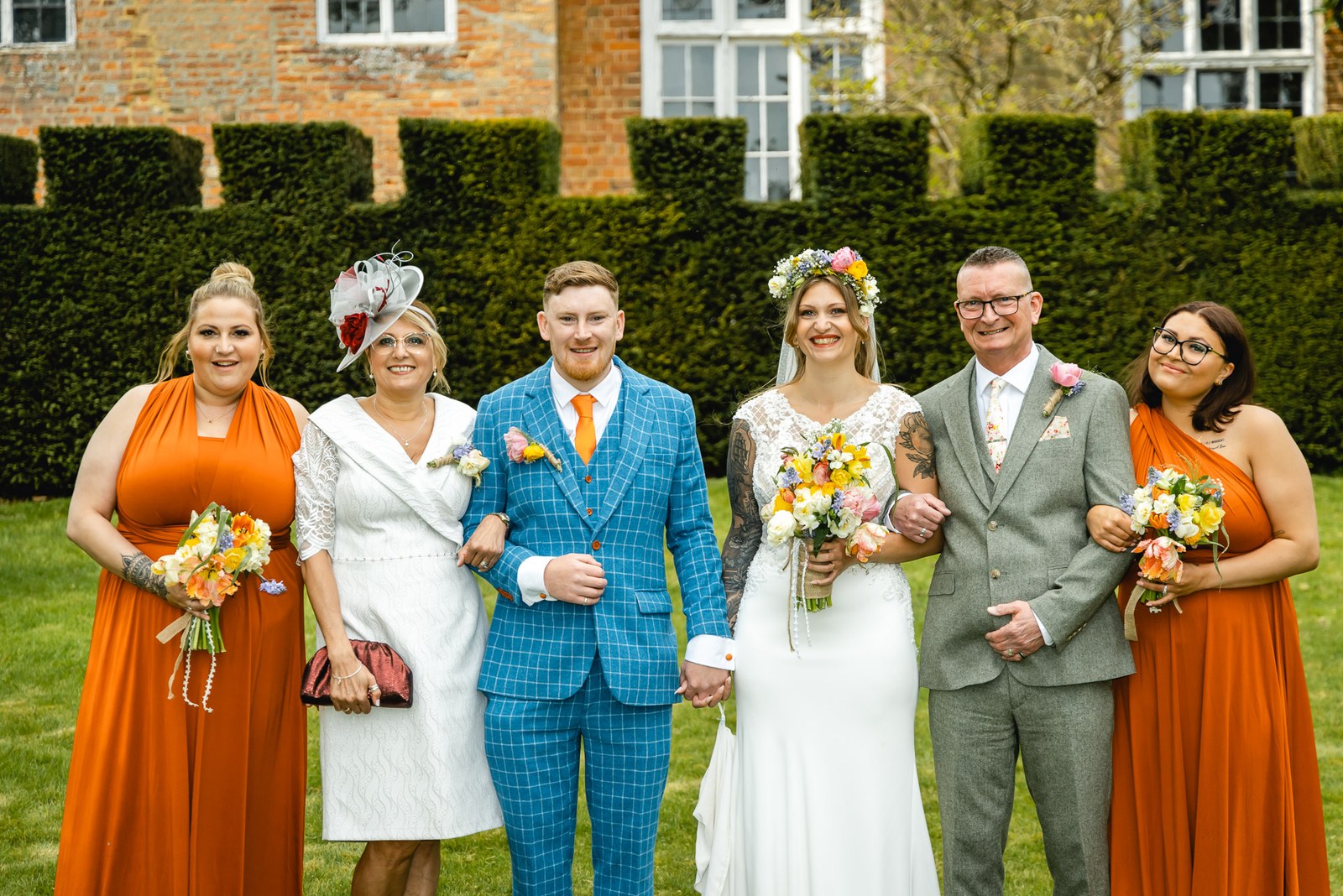 Bride and groom with family on the lawn before Nether Winchendon House