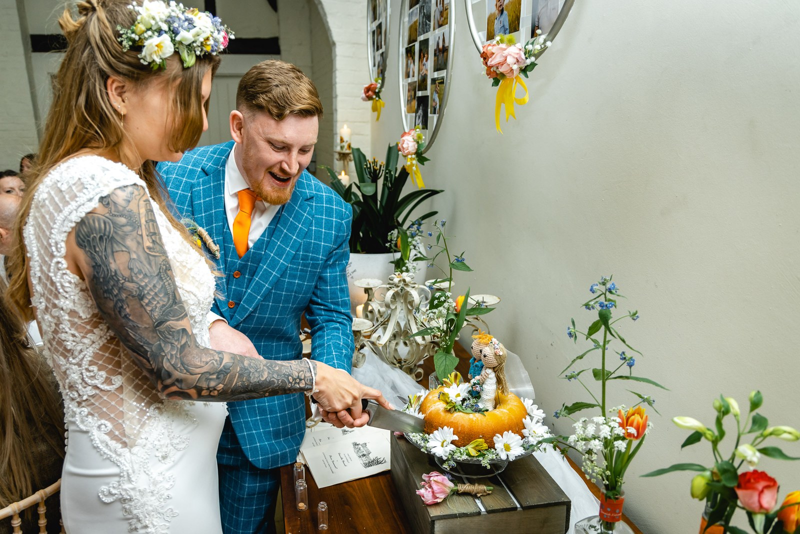 Bride and groom cutting their orange bundt cake with its knitted topper