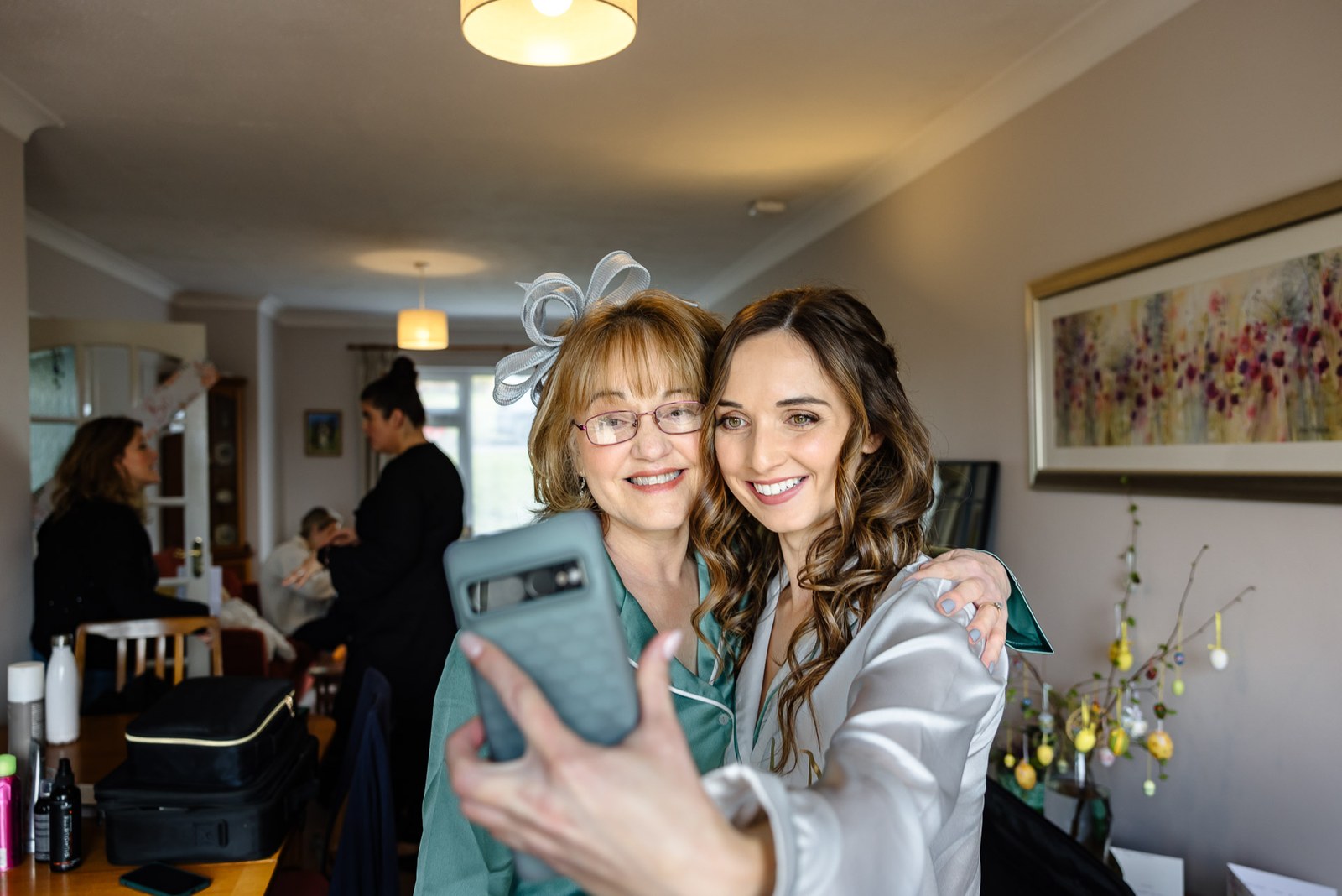 Bride and the mother of the bride taking a selfie in the getting-ready room
