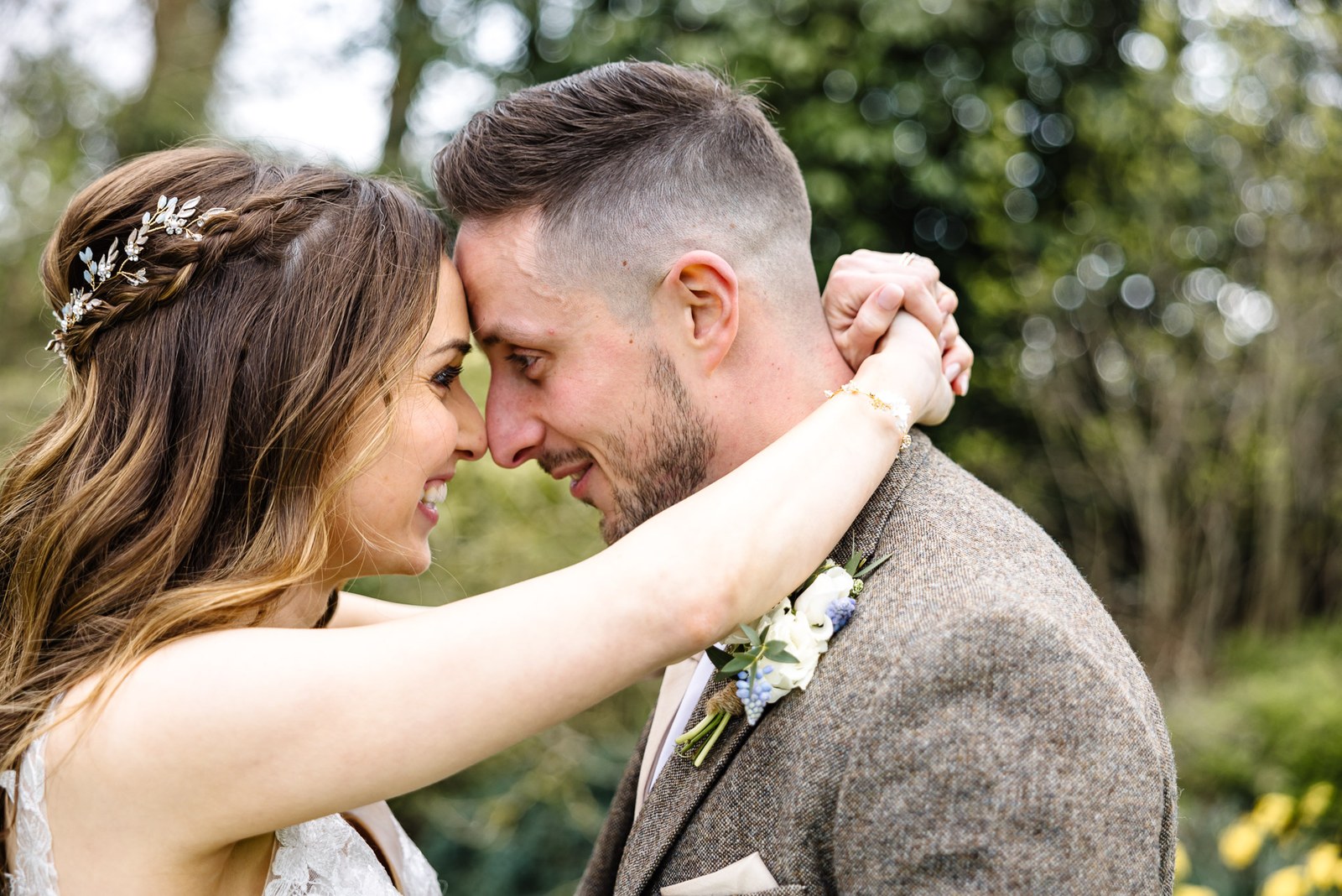 Bride and groom resting their foreheads together in the garden