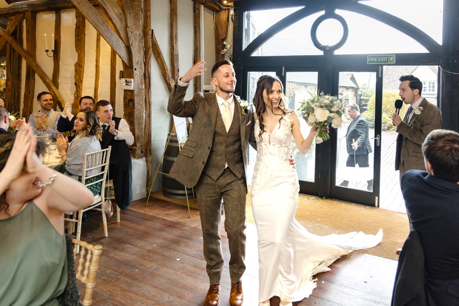 Bride and groom announced into the barn reception as guests applaud