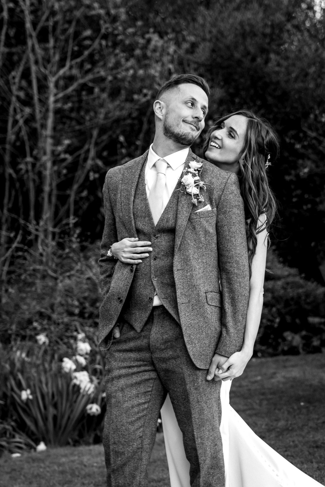 Black and white of the couple embracing, the bride resting on the groom's shoulder