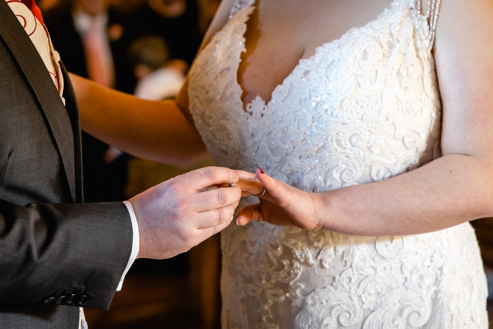 Close-up of the groom sliding a ring onto the bride's finger