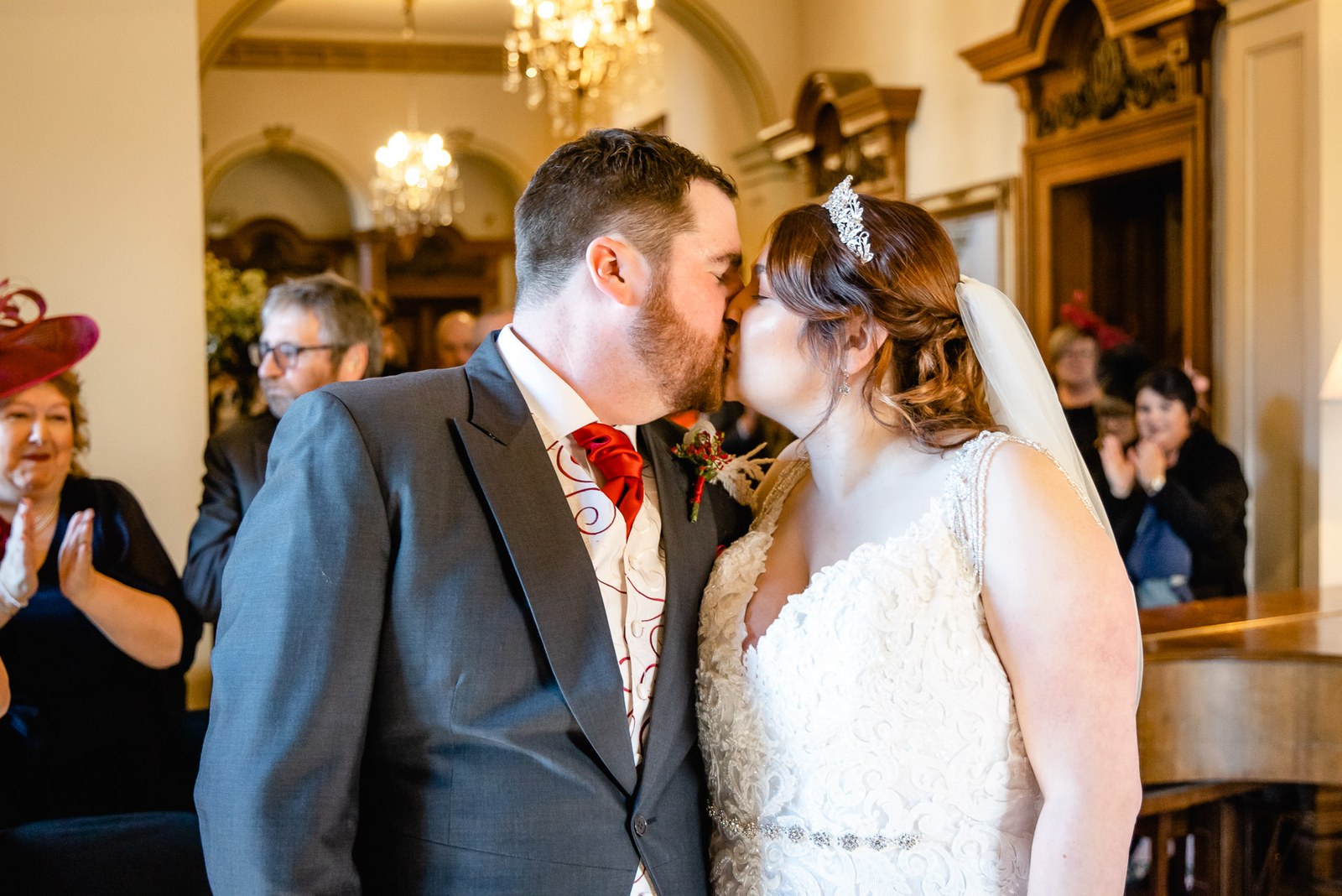 The newlyweds kissing as guests applaud after the ceremony