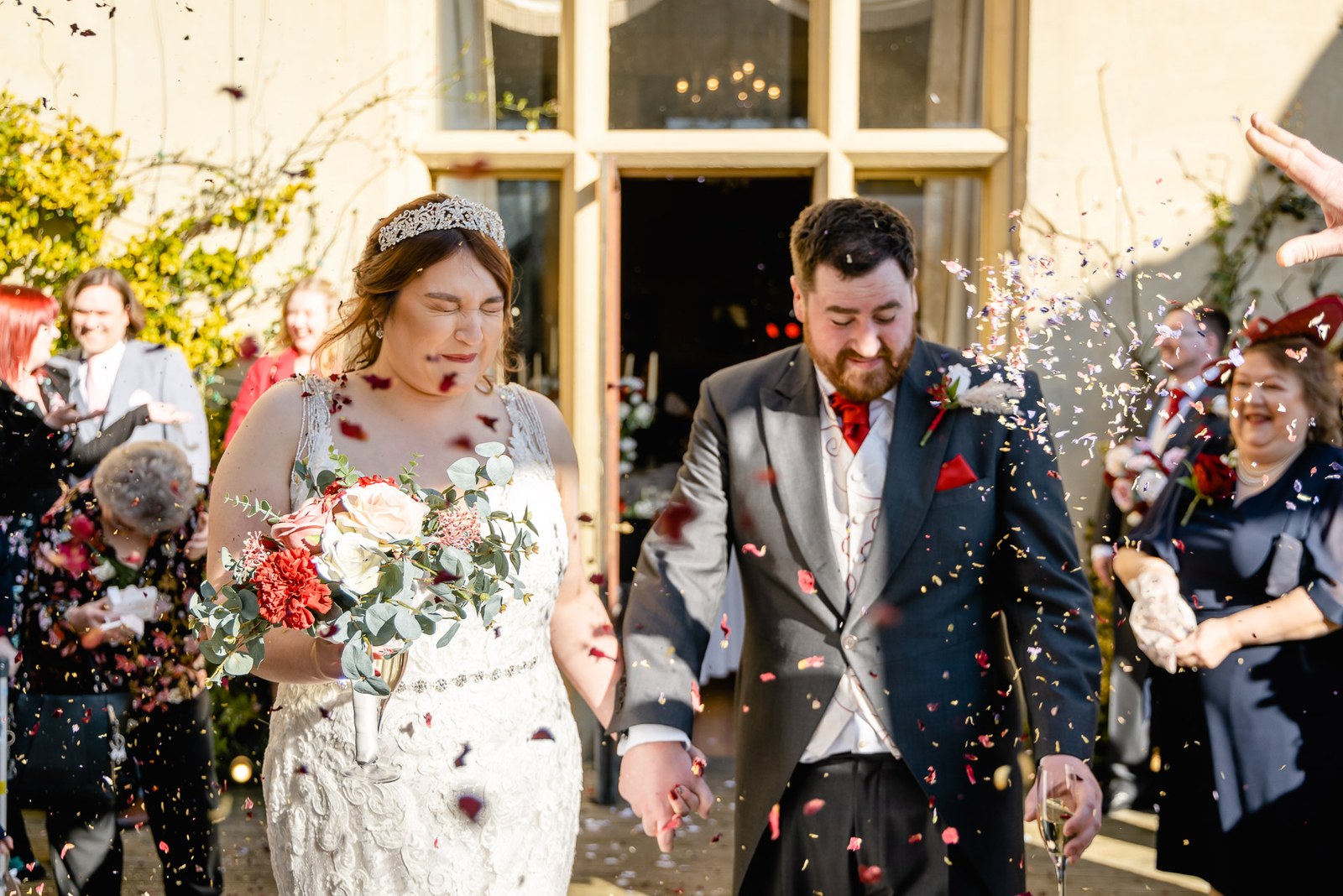 Guests showering the couple with confetti as they step outside